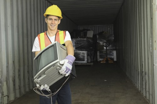 Workers using mechanical aids to lift bulky waste